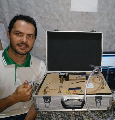  Estudante Charles Fernandes posa ao lado do seu protótipo de respirador, criado com plataforma arduino Crédito: Divulgação 